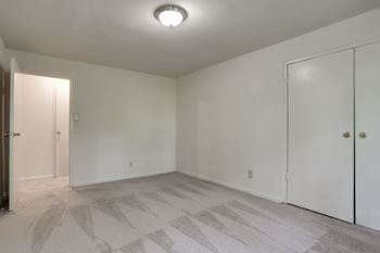 A room with a carpeted floor and a ceiling light